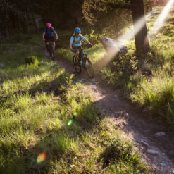 Two women riding single track mountain bike trails